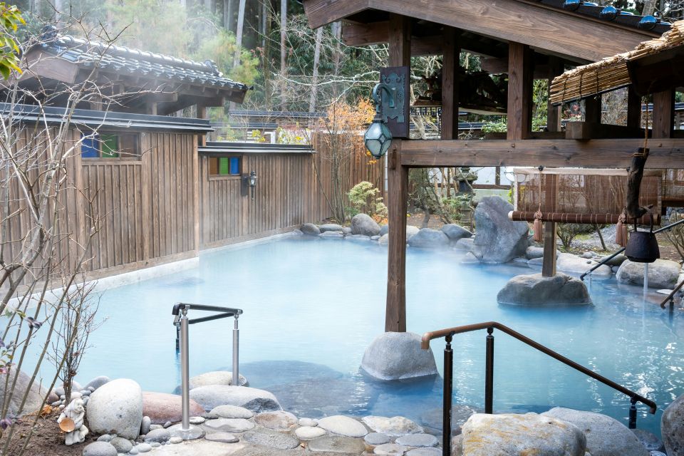 alt="Open-air hot spring bath surrounded by wooden architecture in Japan（日本の木造建築に囲まれた露天風呂）"